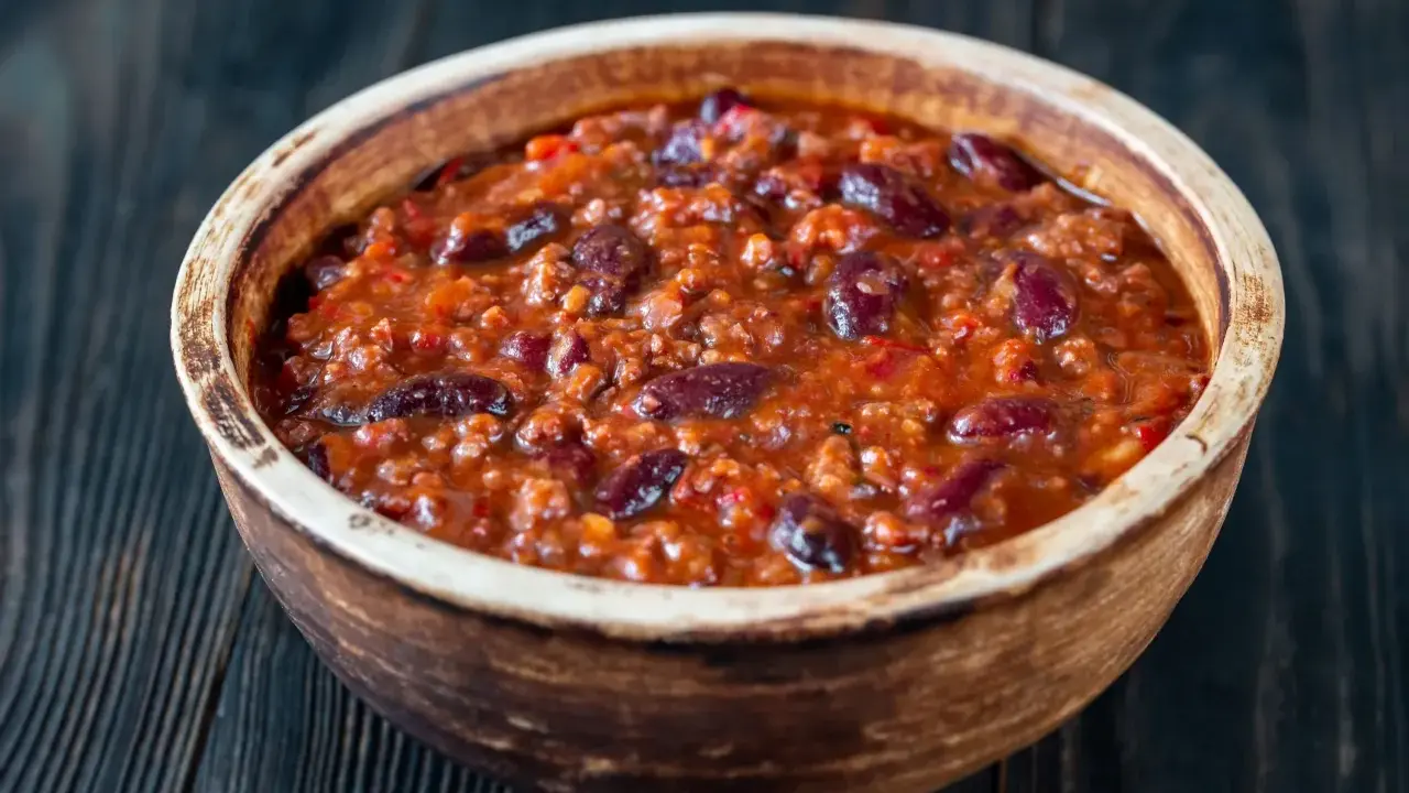 Gęste, aromatyczne chili con carne z fasolą i mielonym mięsem w glinianej misce, gotowe do podania.