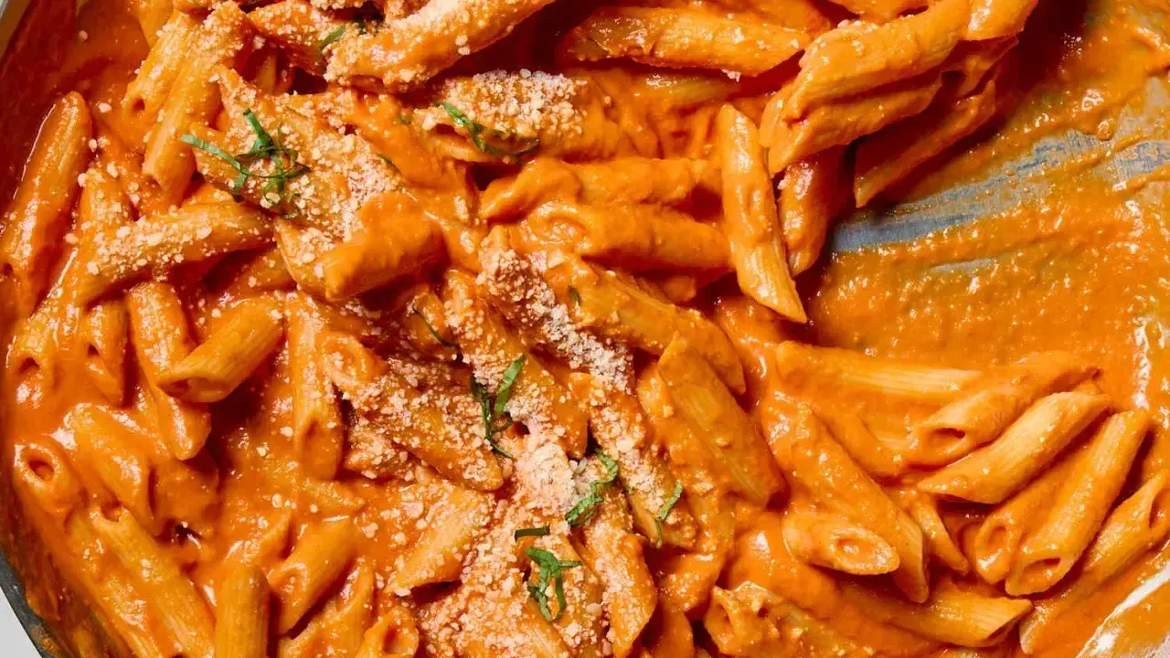 Penne alla vodka w kremowym, pomarańczowym sosie, posypane parmezanem i bazylią. Idealne danie na szybki obiad.
