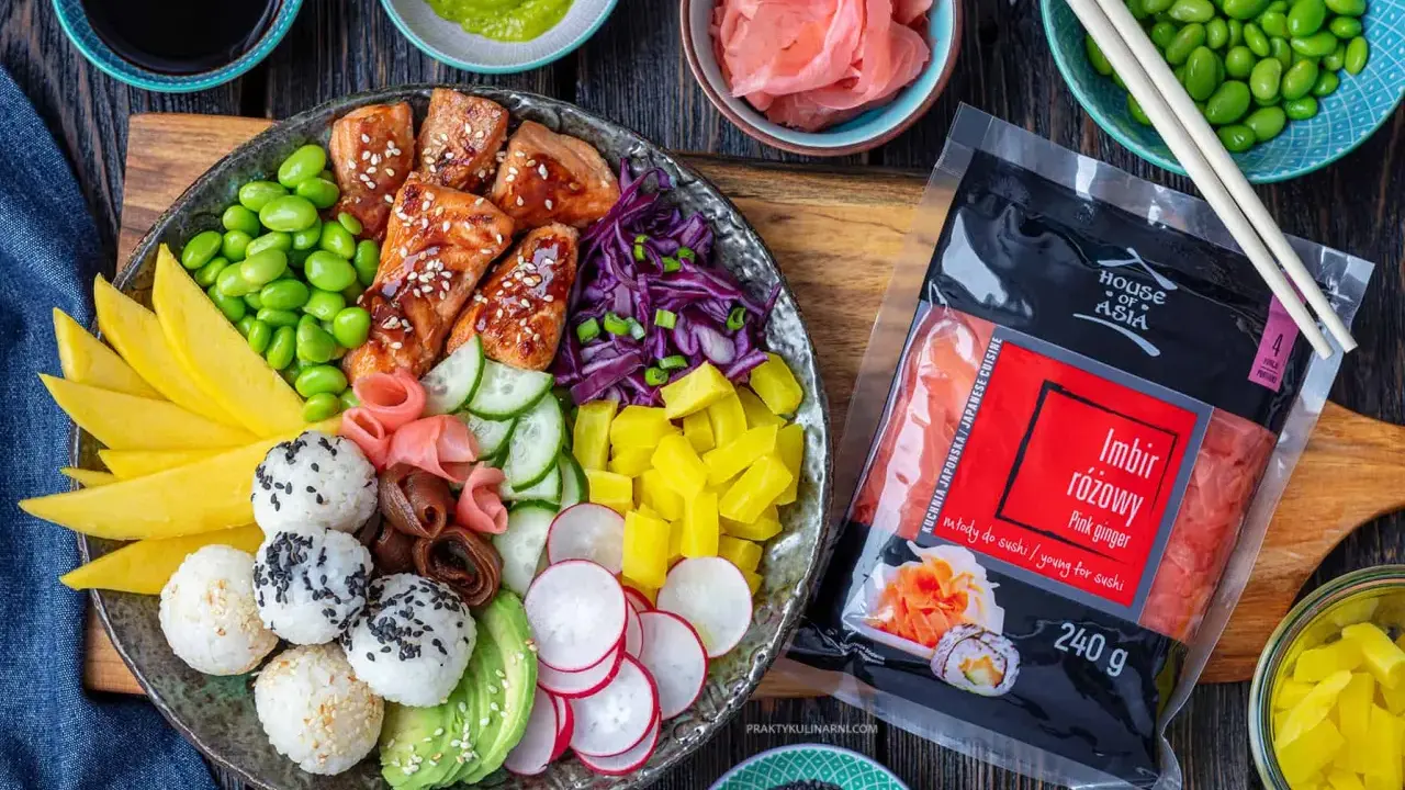 Kolorowy bowl z lososiem, edamame, mango, awokado, ogórkiem, rzodkiewką i ryżem. Obok opakowanie imbiru różowego.