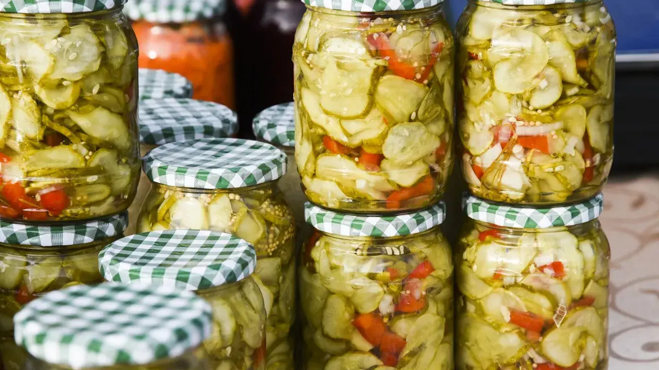 Słoiki z sałatką z ogórków w zalewie gyros, z dodatkiem papryki i cebuli, gotowe do spiżarni.