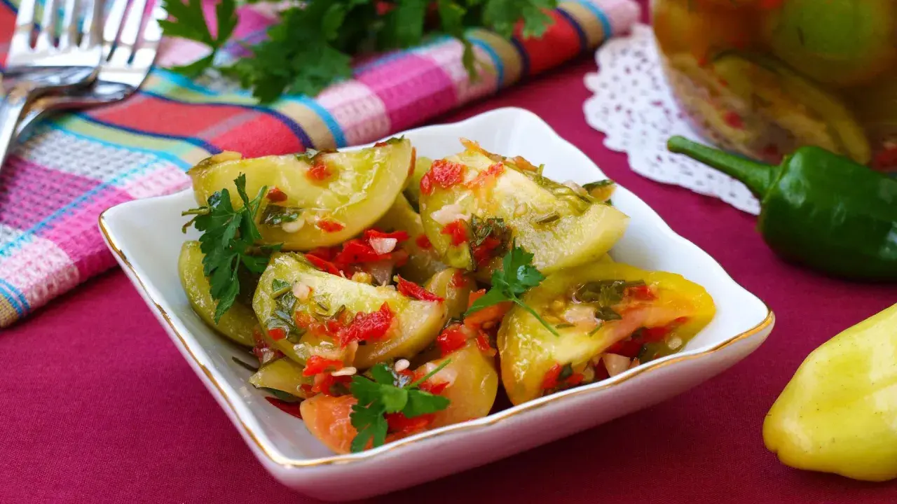 Pikantna sałatka z zielonych pomidorów z papryczką chili i ziołami, gotowa do podania.
