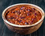Gęste, aromatyczne chili con carne z fasolą i mielonym mięsem w glinianej misce, gotowe do podania.