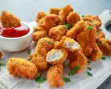 Chrupiący kurczak w panko, idealny do maczania w keczupie. Soczyste kawałki mięsa w złocistej panierce.