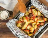Pyszny obiad z piekarnika: pieczone ziemniaki z mięsem i papryczką chili, zawinięte w folię aluminiową.