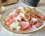 Pyszna sałatka z pomidora, ogórka i cebuli w kremowym sosie. Idealna na letni obiad.