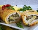 Pyszna rolada serowa z kurczakiem, nadziewana grzybami i szpinakiem, ozdobiona papryczką chili.