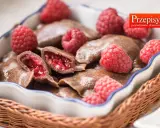 Czekoladowe pierogi z malinami, podane w koszyku, z malinami i śmietaną. Prawdziwie domowa kuchnia.