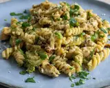 Pyszny makaron z brokułami, kurczakiem i suszonymi pomidorami, posypany parmezanem i natką pietruszki.