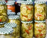 Słoiki z sałatką z ogórków w zalewie gyros, z dodatkiem papryki i cebuli, gotowe do spiżarni.