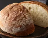Chleb bez drożdży z chrupiącą skórką i puszystym wnętrzem, pokrojony na desce.