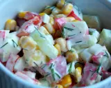 Pyszna sałatka z surimi, kukurydzy, ogórka i papryki, polana kremowym sosem i posypana koperkiem.