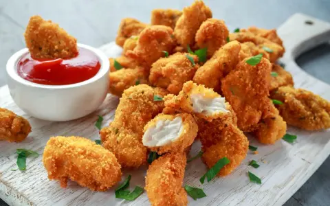 Chrupiący kurczak w panko, idealny do maczania w keczupie. Soczyste kawałki mięsa w złocistej panierce.