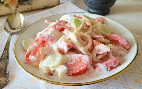 Pyszna sałatka z pomidora, ogórka i cebuli w kremowym sosie. Idealna na letni obiad.