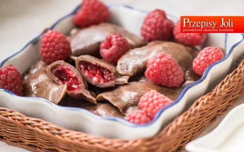 Czekoladowe pierogi z malinami, podane w koszyku, z malinami i śmietaną. Prawdziwie domowa kuchnia.