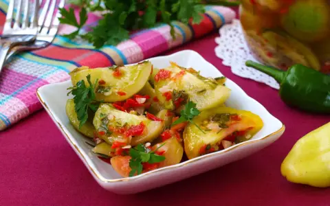 Pikantna sałatka z zielonych pomidorów z papryczką chili i ziołami, gotowa do podania.
