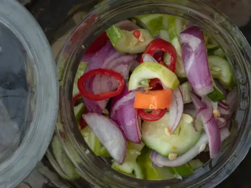 Słoik pełen świeżej sałatki z ogórków z chili, cebuli i papryki. Idealna na lato!