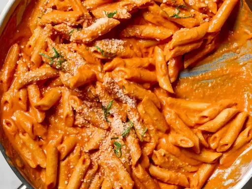 Penne alla vodka w kremowym, pomarańczowym sosie, posypane parmezanem i bazylią. Idealne danie na szybki obiad.