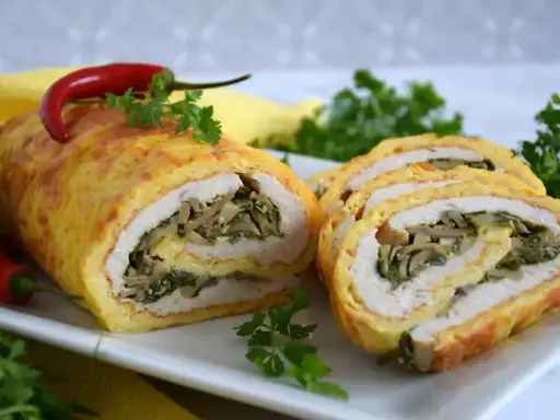 Pyszna rolada serowa z kurczakiem, nadziewana grzybami i szpinakiem, ozdobiona papryczką chili.