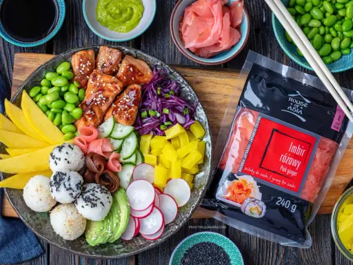 Kolorowy bowl z lososiem, edamame, mango, awokado, ogórkiem, rzodkiewką i ryżem. Obok opakowanie imbiru różowego.