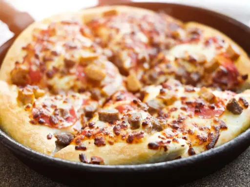 Pyszna pizza z patelni, z ciągnącym się serem i kawałkami mięsa, gotowa do podania.
