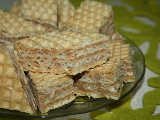 Chrupiące wafle z kremem o smaku mleka w proszku, ułożone na talerzyku.