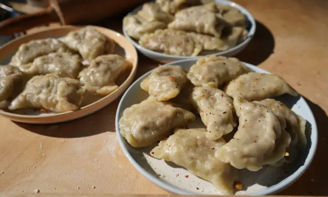 Trzy talerze pełne pysznych, domowych pierogów z soczewicą, posypanych przyprawami.