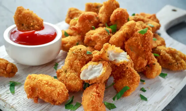 Chrupiący kurczak w panko, idealny do maczania w keczupie. Soczyste kawałki mięsa w złocistej panierce.