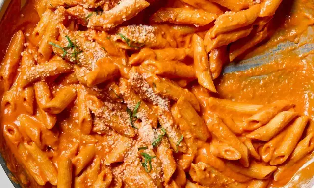 Penne alla vodka w kremowym, pomarańczowym sosie, posypane parmezanem i bazylią. Idealne danie na szybki obiad.