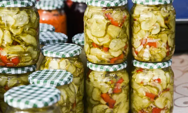 Słoiki z sałatką z ogórków w zalewie gyros, z dodatkiem papryki i cebuli, gotowe do spiżarni.