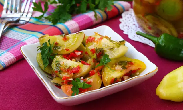 Pikantna sałatka z zielonych pomidorów z papryczką chili i ziołami, gotowa do podania.