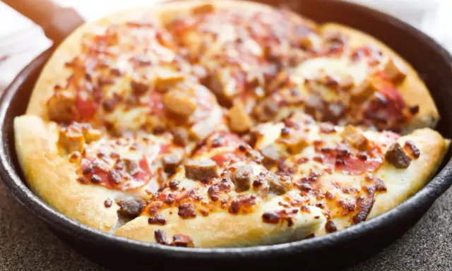 Pyszna pizza z patelni, z ciągnącym się serem i kawałkami mięsa, gotowa do podania.