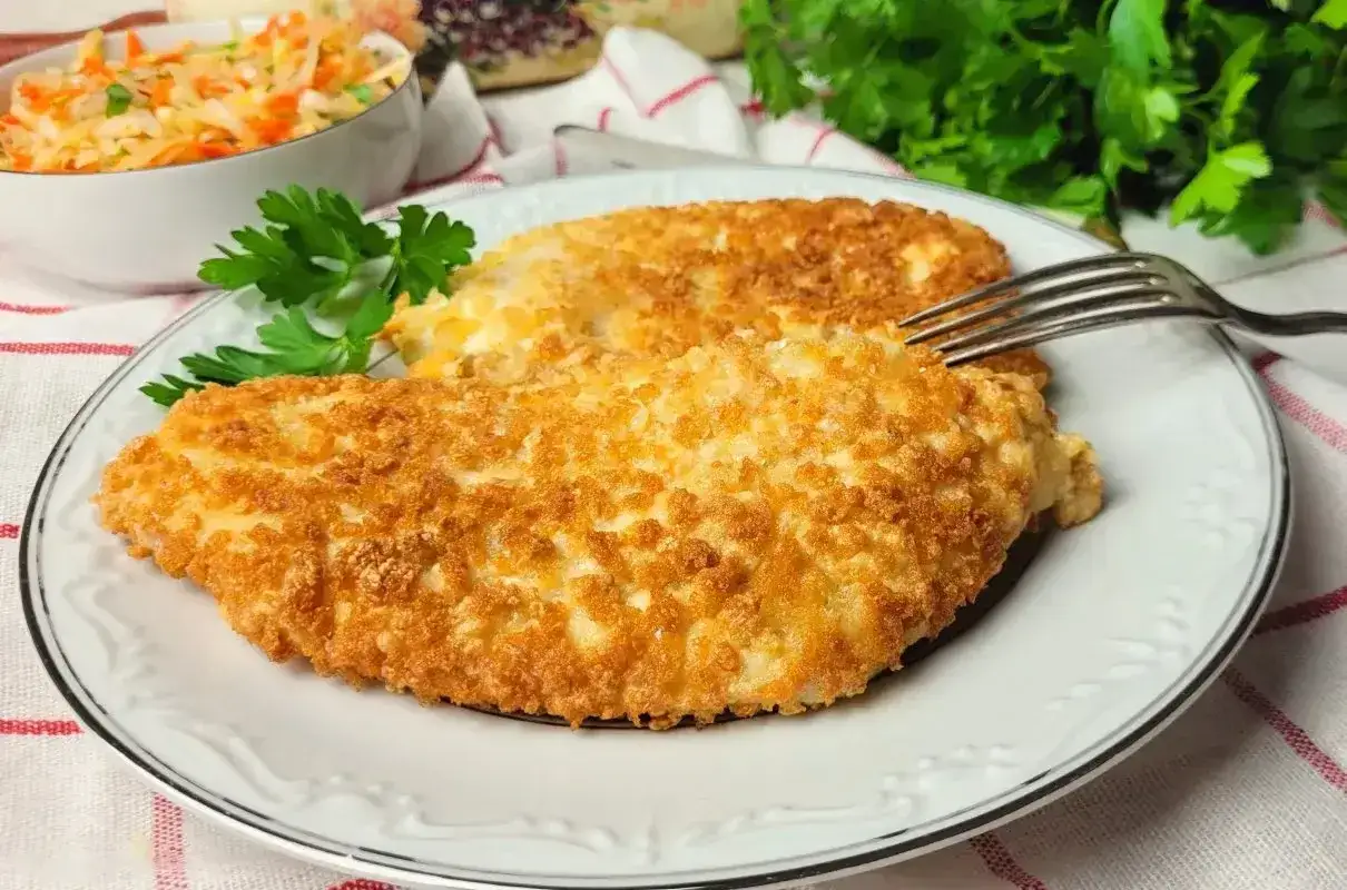 Chrupiący kurczak w panko na talerzu, obok miseczki z surówką. Idealny obiad gotowy!