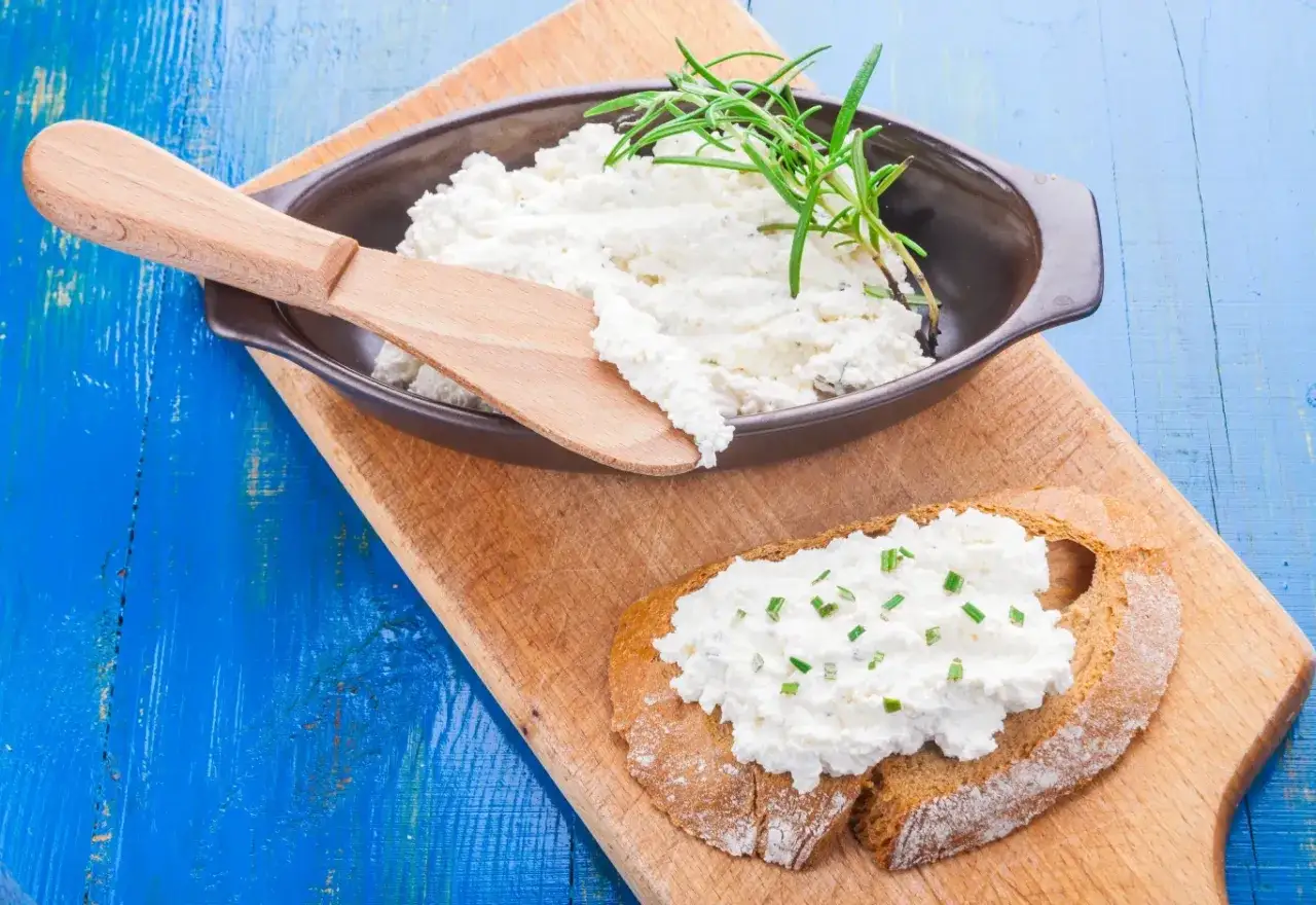 Puszysty ser po gruzińsku z ziołami, podany na chlebie i w miseczce, gotowy do degustacji.