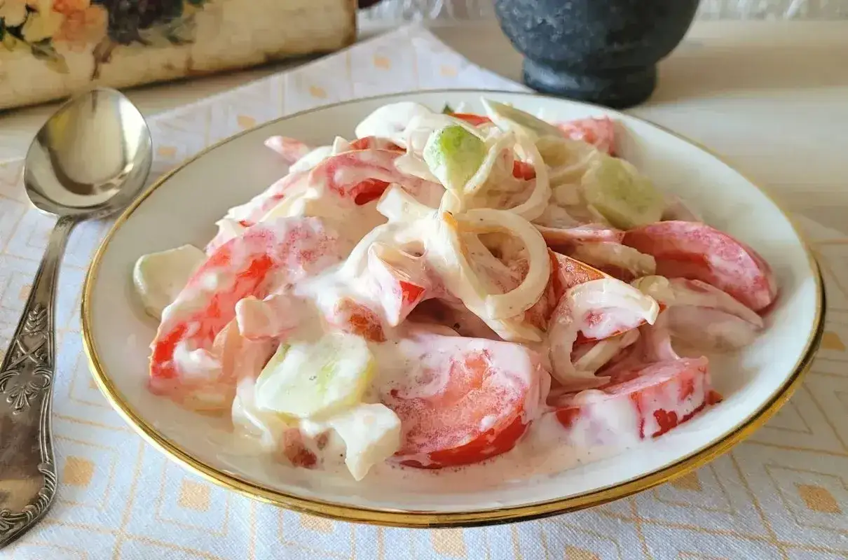 Pyszna sałatka z pomidora, og&oacute;rka i cebuli w kremowym sosie. Idealna na letni obiad.
