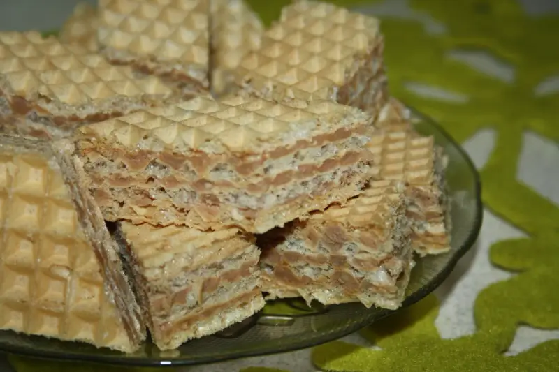 Chrupiące wafle z kremem o smaku mleka w proszku, ułożone na talerzyku.